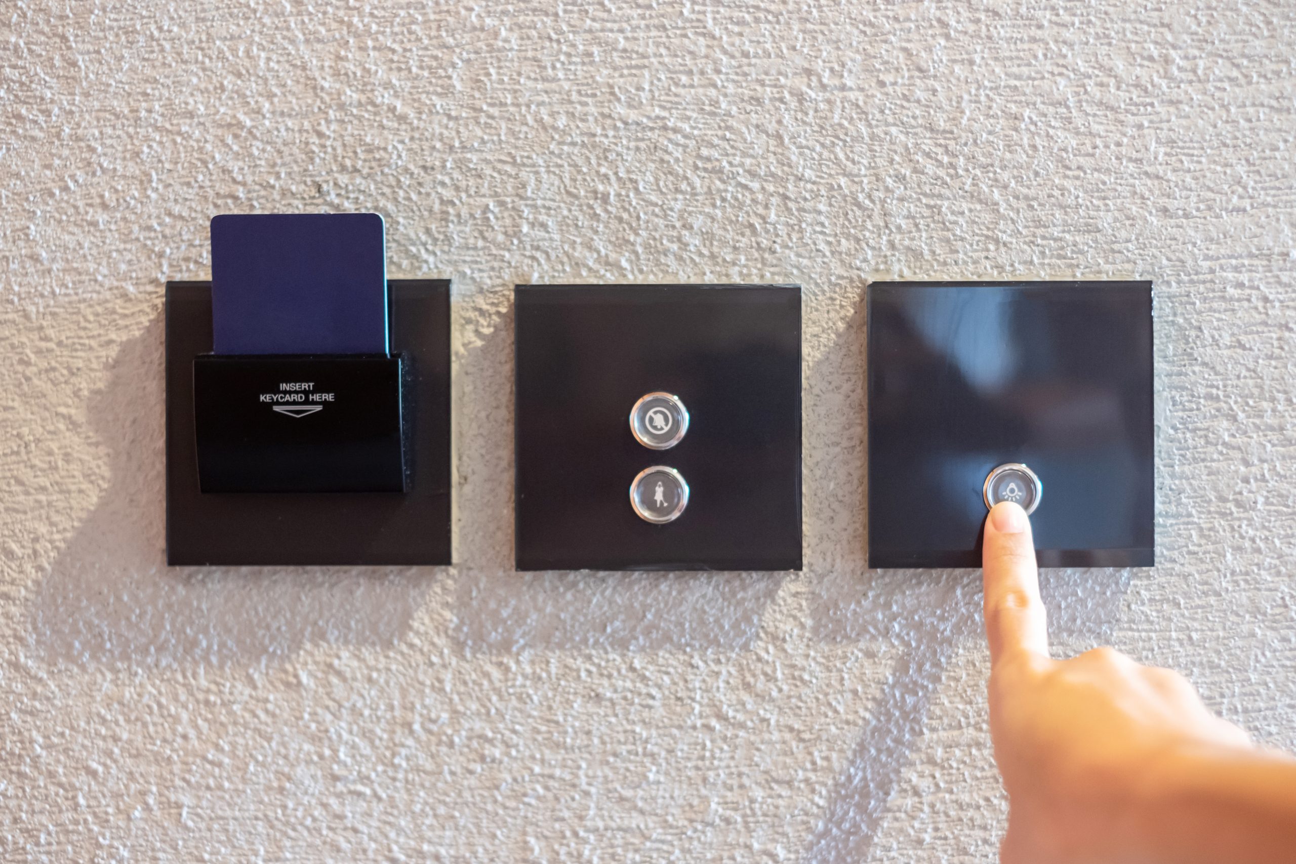 finger turn on or off on modern light switch on wall at home. Energy Saving, power, electrical and lifestyle concepts